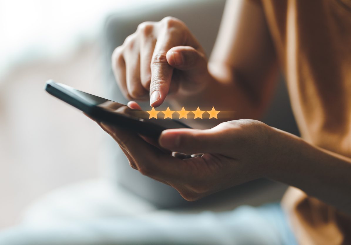 Close up of woman customer giving a five star rating on smartphone. Review, Service rating, satisfaction, Customer service experience and satisfaction survey concept.